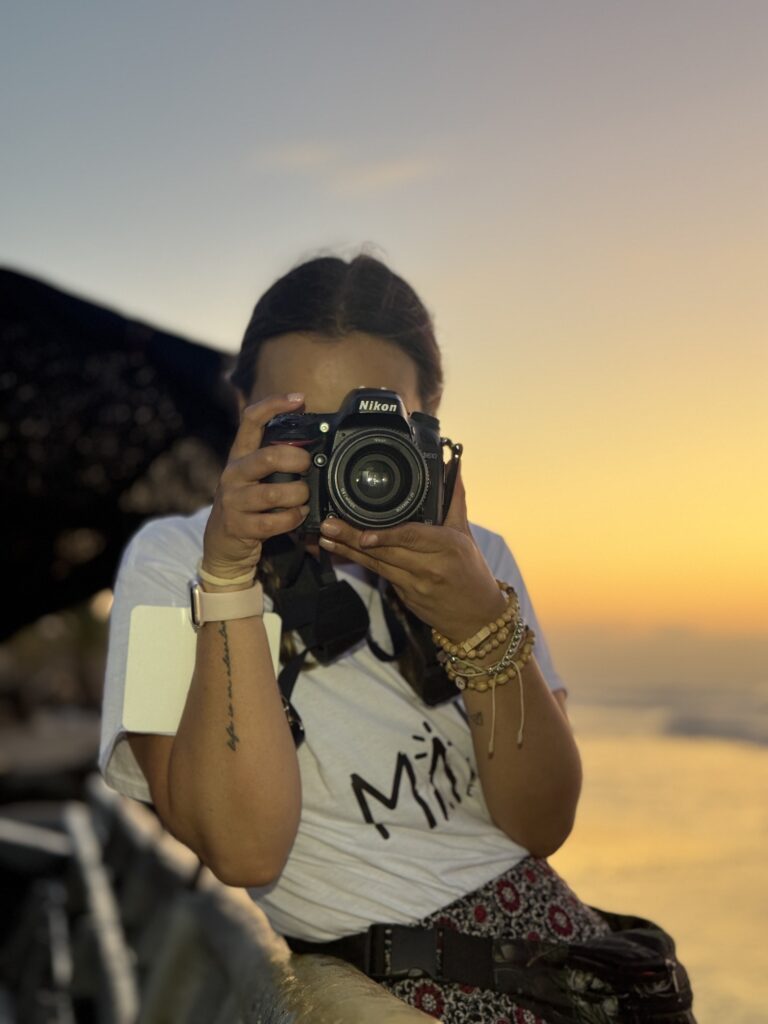 Alejandra Salcedo tomando una fotografía al atardecer