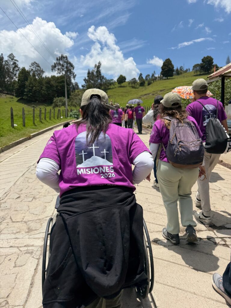 Misioneros de Puro Love acompañando a una persona en silla de ruedas